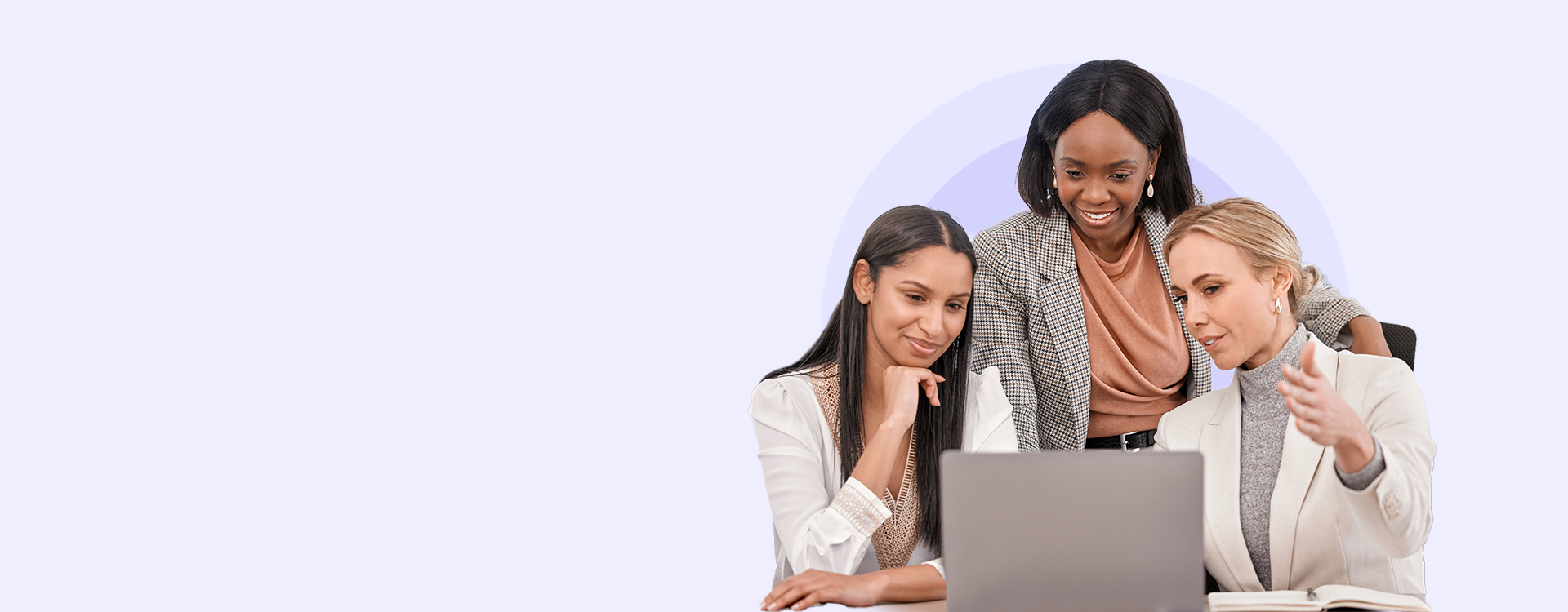 Three professional women collaborating and reviewing information on a laptop, representing VanderHouwen's expertise in helping businesses build the perfect team in Technology, Engineering, Accounting and Finance, and Human Resources.